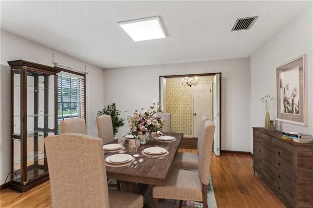 194 Sedgefield Dr, Harahan, LA 70123 - dining space with wood finished floors, a chandelier, and baseboards