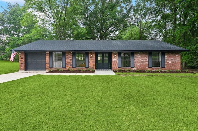 ranch-style house featuring concrete driveway, a front yard, brick siding, and a garage