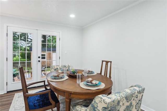 dining space featuring baseboards, ornamental molding, wood finished floors, and french doors