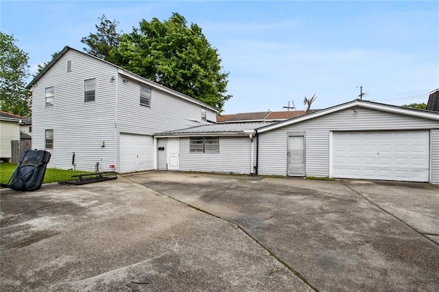 back of house with a garage and driveway