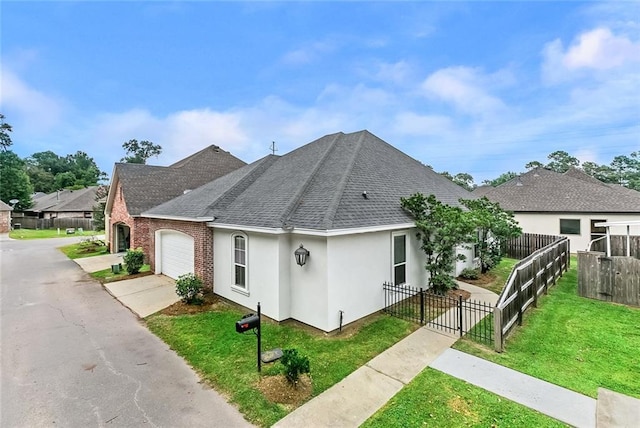 view of front of home featuring a shingled roof, a front yard, stucco siding, fence private yard, and a garage