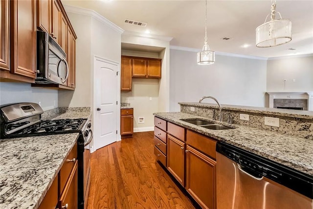 kitchen with a sink, visible vents, stainless steel appliances, dark wood-type flooring, and brown cabinetry