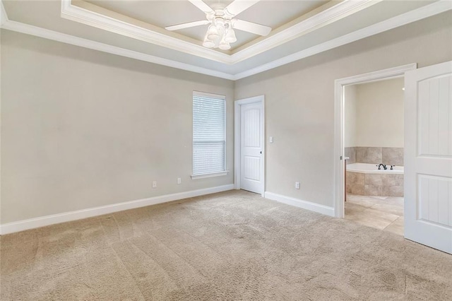 unfurnished bedroom featuring connected bathroom, a raised ceiling, baseboards, ornamental molding, and carpet