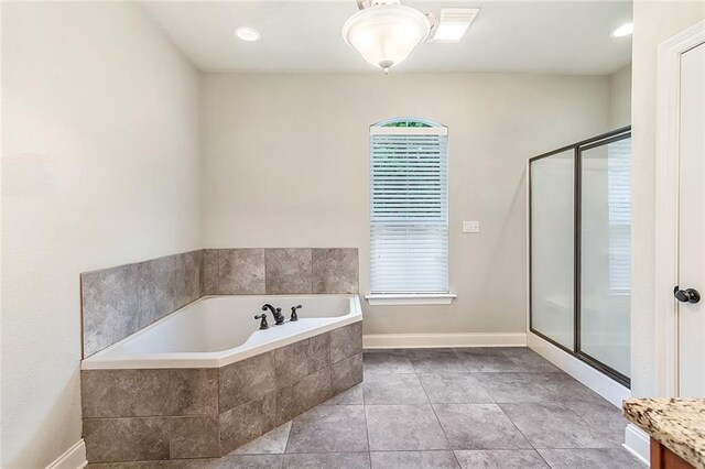 full bath featuring a shower stall, a bath, and baseboards