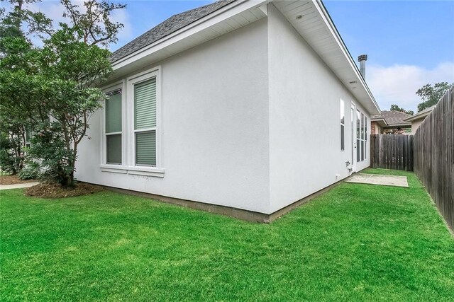 view of home's exterior with a fenced backyard, stucco siding, and a lawn