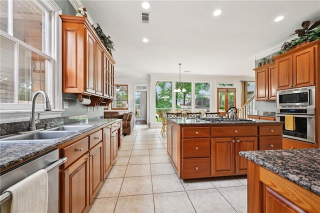 454 Rutherford Dr, Covington, LA 70433 - kitchen featuring a sink, stainless steel appliances, brown cabinetry, visible vents, and a kitchen island