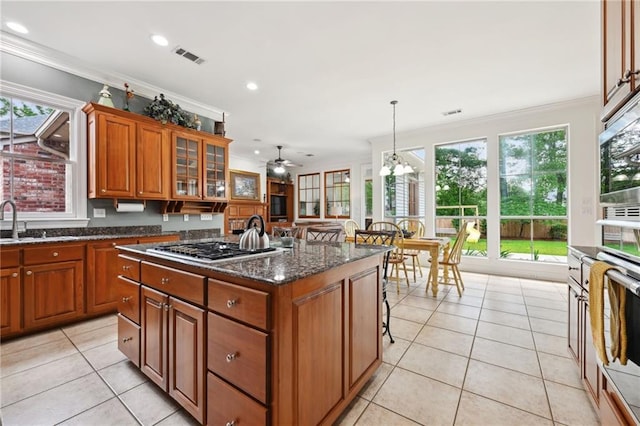 454 Rutherford Dr, Covington, LA 70433 - kitchen with light tile patterned floors, stainless steel appliances, plenty of natural light, and brown cabinets