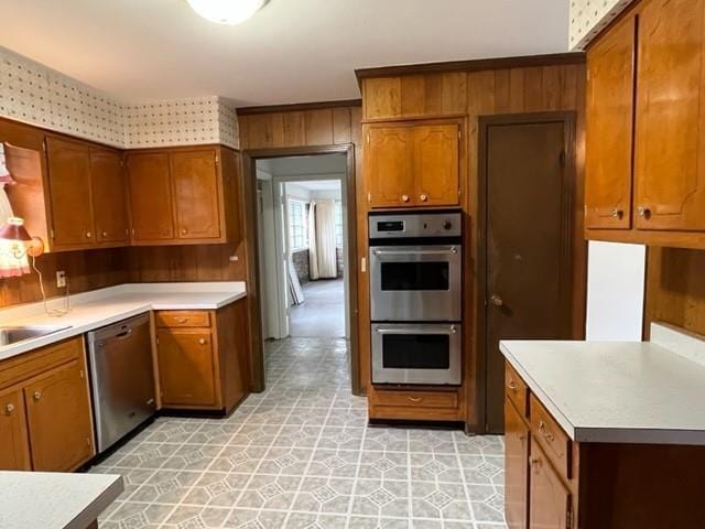 1736 11th St, Slidell, LA 70458 - kitchen with stainless steel appliances, light countertops, brown cabinetry, light flooring, and wood walls