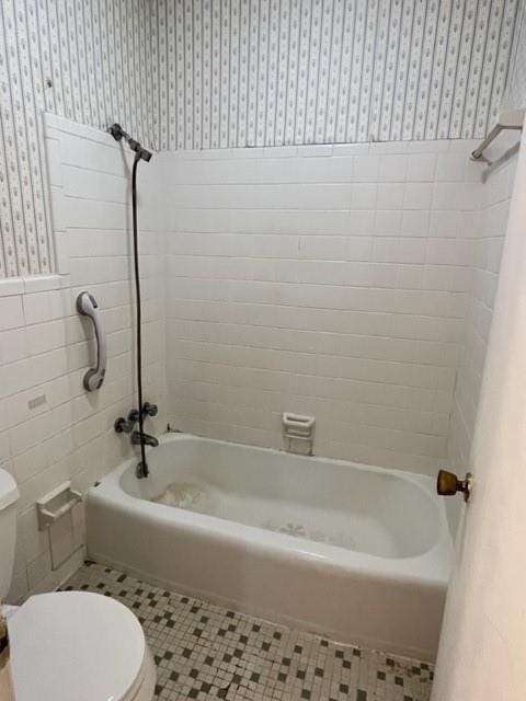 1736 11th St, Slidell, LA 70458 - full bath with wallpapered walls, toilet, a wainscoted wall, tile walls, and shower / bathtub combination