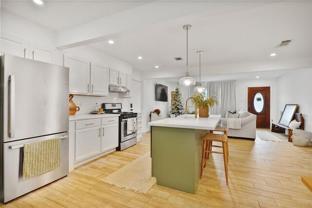 117 Diane Ave, River Ridge, LA 70123 - kitchen featuring stainless steel appliances, under cabinet range hood, white cabinetry, light wood-style flooring, and recessed lighting