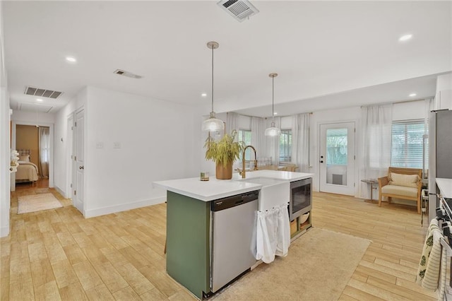 117 Diane Ave, River Ridge, LA 70123 - kitchen with stainless steel appliances, light countertops, light wood-type flooring, a kitchen island with sink, and recessed lighting