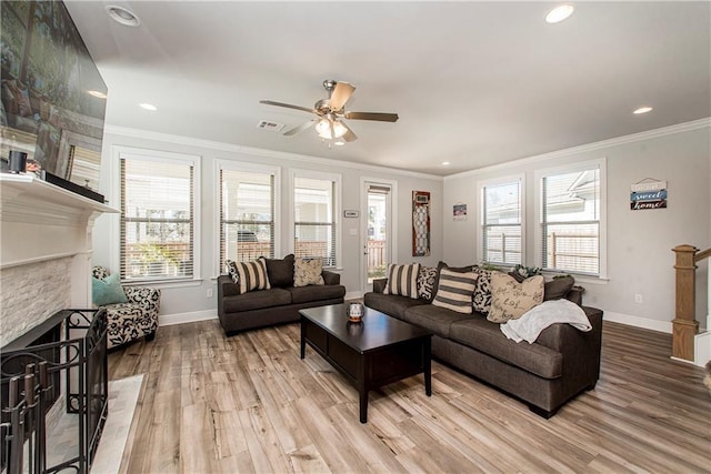2329 Bradbury Pl, Covington, LA 70433 - living area with a ceiling fan, a stone fireplace, crown molding, baseboards, and light wood-style flooring