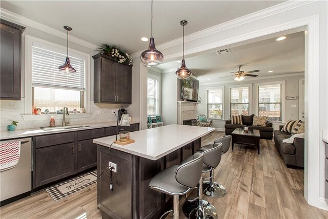 2329 Bradbury Pl, Covington, LA 70433 - kitchen featuring a sink, a kitchen bar, open floor plan, and dark brown cabinets