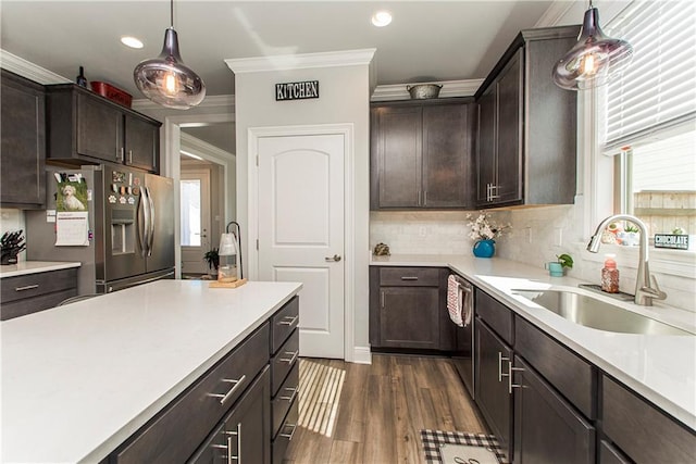 2329 Bradbury Pl, Covington, LA 70433 - kitchen with dark brown cabinetry, appliances with stainless steel finishes, a sink, light countertops, and ornamental molding