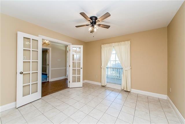 spare room with french doors, baseboards, a ceiling fan, and light tile patterned floors