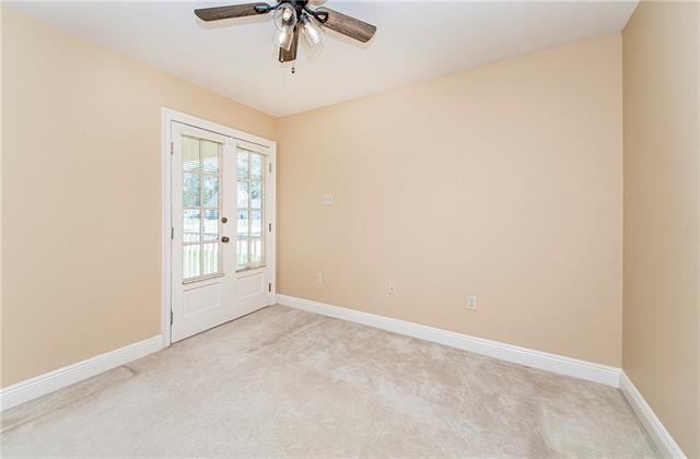 empty room featuring light colored carpet, ceiling fan, and baseboards