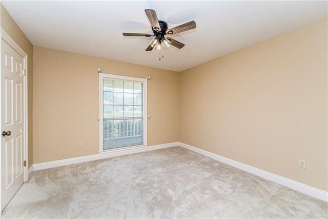 empty room featuring baseboards, light colored carpet, and ceiling fan