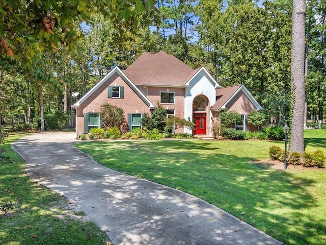 8063 Winners Cir, Mandeville, LA 70448 - view of front of home with brick siding, a front yard, and asphalt driveway