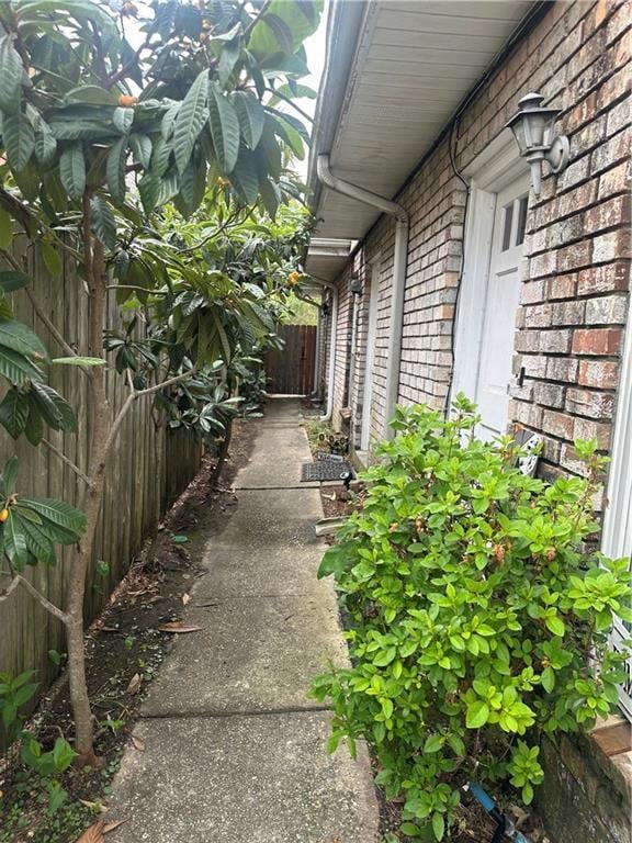 view of side of property with brick siding and a fenced backyard