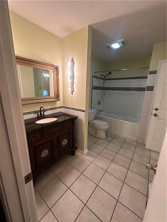 full bath with shower / tub combination, a textured ceiling, toilet, and tile patterned flooring