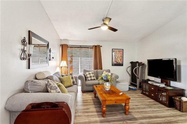 living room with ceiling fan, light wood-type flooring, and vaulted ceiling