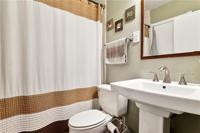 full bathroom with toilet and a shower with curtain