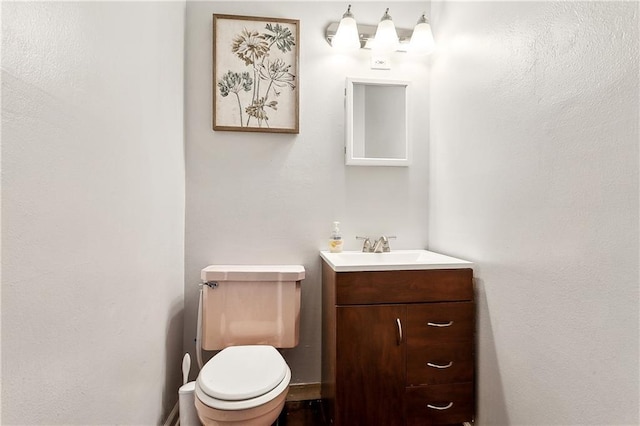 half bathroom featuring toilet and vanity