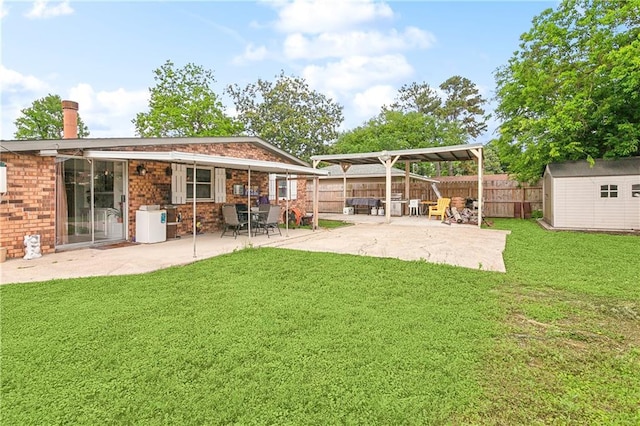 back of property with an outdoor structure, a patio, a yard, brick siding, and a fenced backyard