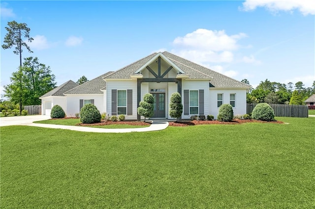 view of front of house featuring driveway, a front yard, an attached garage, fence, and french doors