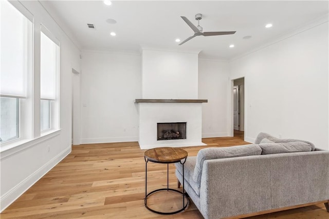 living room with visible vents, ceiling fan, light wood-type flooring, recessed lighting, and ornamental molding