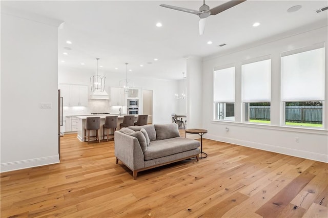 living area with baseboards, recessed lighting, and light wood finished floors