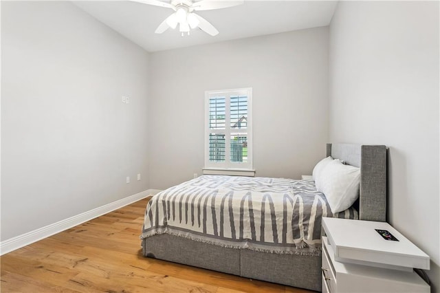 bedroom with a ceiling fan, wood finished floors, and baseboards
