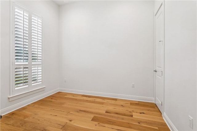 unfurnished room with light wood-style flooring and baseboards