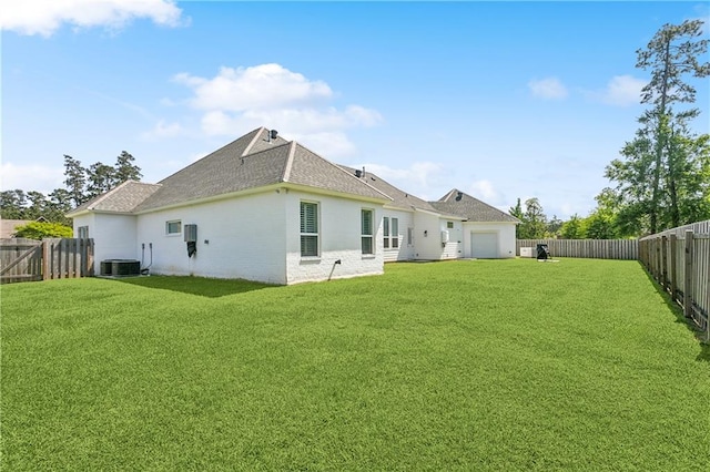 back of house with a lawn, roof with shingles, central AC unit, and a fenced backyard