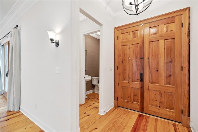 386 Marina Blvd, Mandeville, LA 70471 - foyer with ornamental molding, light wood-style flooring, baseboards, and a chandelier
