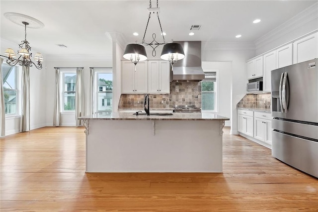 386 Marina Blvd, Mandeville, LA 70471 - kitchen featuring appliances with stainless steel finishes, ventilation hood, a chandelier, crown molding, and light stone counters