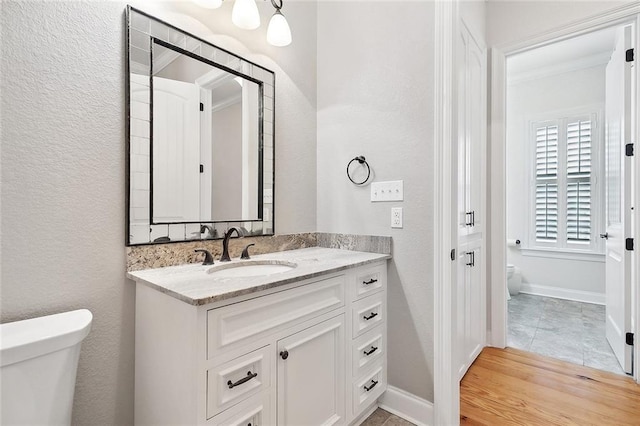 386 Marina Blvd, Mandeville, LA 70471 - bathroom featuring toilet, vanity, baseboards, a textured wall, and crown molding