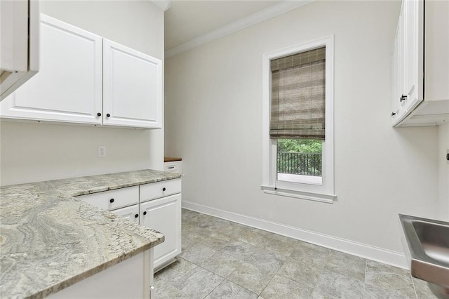 386 Marina Blvd, Mandeville, LA 70471 - kitchen featuring white cabinetry, baseboards, light stone countertops, and crown molding