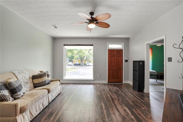 2254 9th St, Mandeville, LA 70471 - living room featuring a ceiling fan, dark wood-style flooring, a textured ceiling, and baseboards