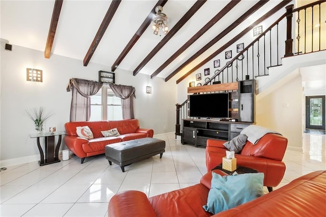 tiled living area with beamed ceiling, high vaulted ceiling, ceiling fan, stairs, and baseboards