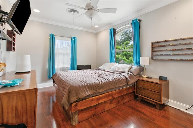 bedroom with wood finished floors, visible vents, ornamental molding, and multiple windows
