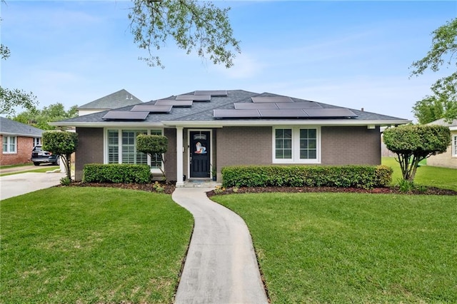 535 Amethyst St, New Orleans, LA 70124 - view of front facade with roof mounted solar panels, roof with shingles, a front lawn, and brick siding
