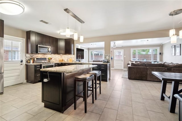 535 Amethyst St, New Orleans, LA 70124 - kitchen featuring visible vents, dark brown cabinets, open floor plan, a center island, and stainless steel appliances