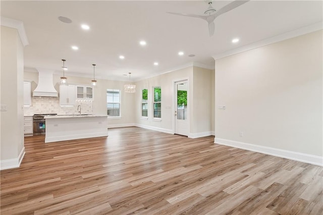 unfurnished living room featuring recessed lighting, a sink, and light wood-style flooring