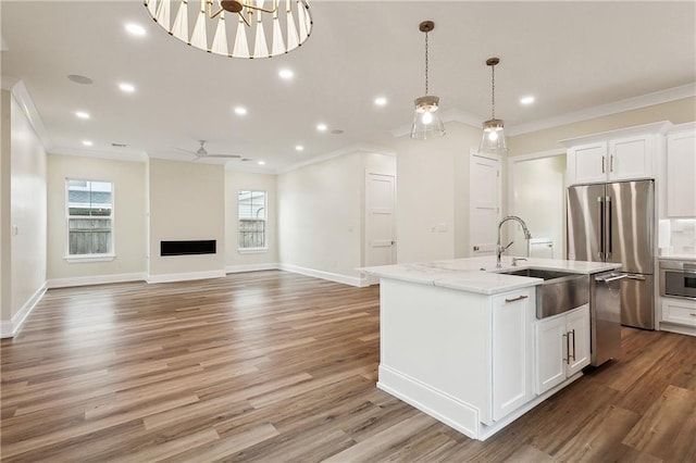 3117 41st St, Metairie, LA 70001 - kitchen with crown molding, stainless steel appliances, ceiling fan, a center island with sink, and a fireplace