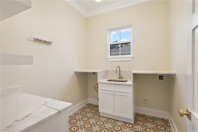 washroom featuring cabinet space, light tile patterned floors, baseboards, and a sink
