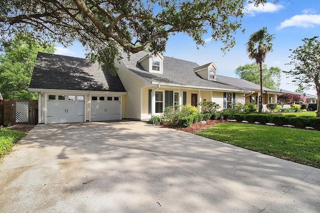 18 Landsdowne Ln, Destrehan, LA 70047 - cape cod home with fence, a front lawn, concrete driveway, and an attached garage