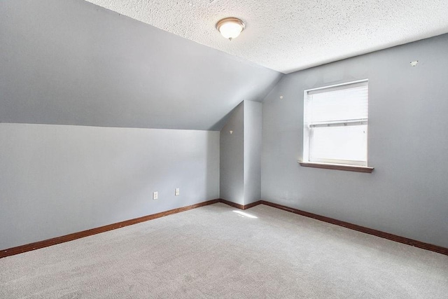 18 Landsdowne Ln, Destrehan, LA 70047 - additional living space with a textured ceiling, baseboards, vaulted ceiling, and carpet floors