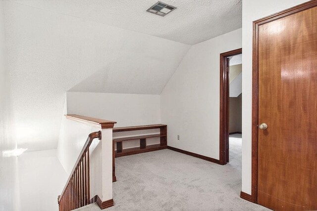 18 Landsdowne Ln, Destrehan, LA 70047 - additional living space featuring a textured ceiling, visible vents, baseboards, vaulted ceiling, and carpet