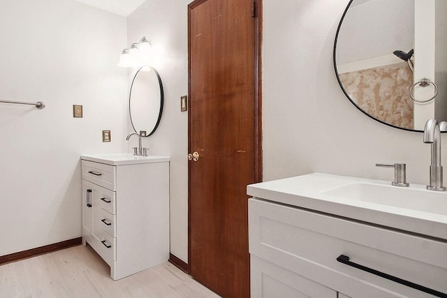 18 Landsdowne Ln, Destrehan, LA 70047 - bathroom with two vanities, wood finished floors, baseboards, and a sink